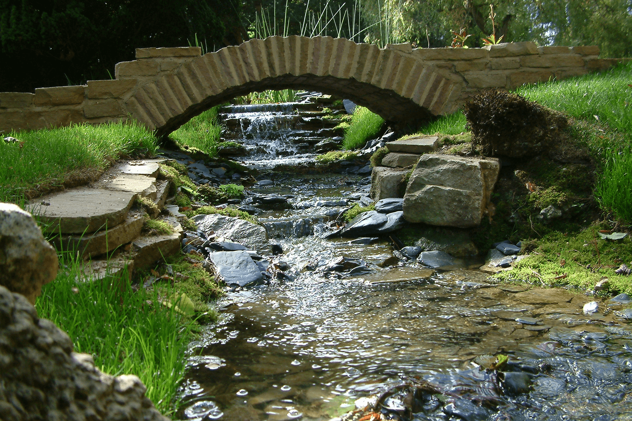 A stone arch bridge over a small stream